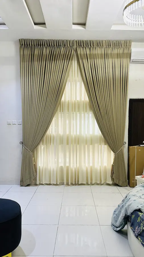 Olive and gold pleated curtains across a double window