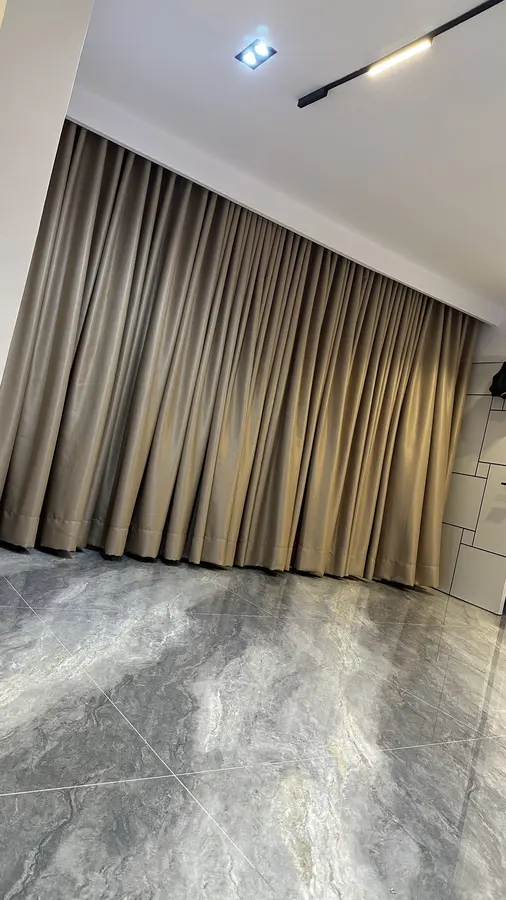 Wide bronze drapery across a living room opening