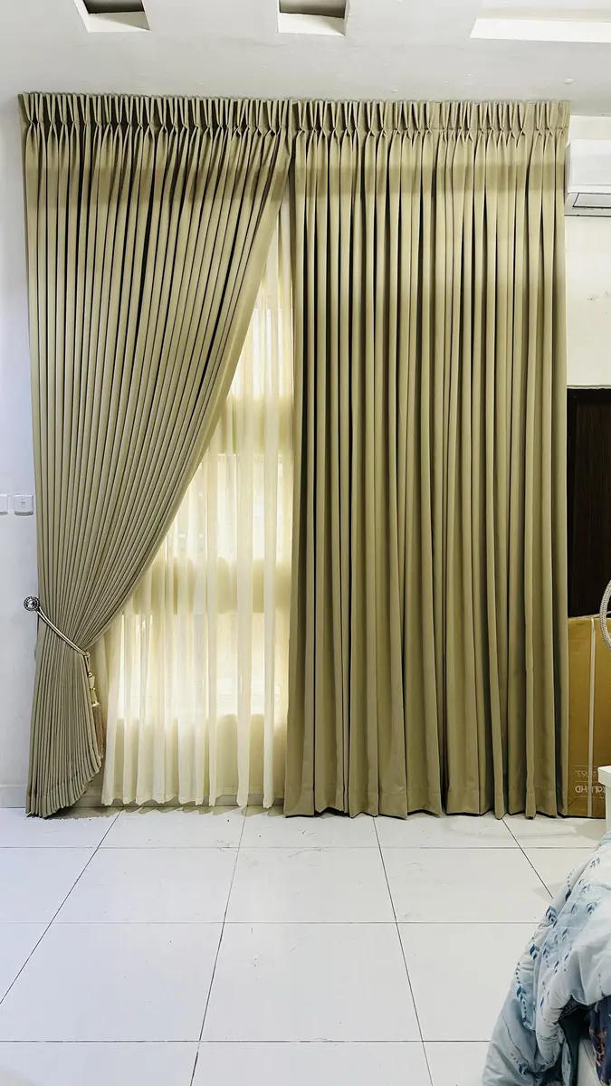 Tan pleated curtains with tieback in a bright living room